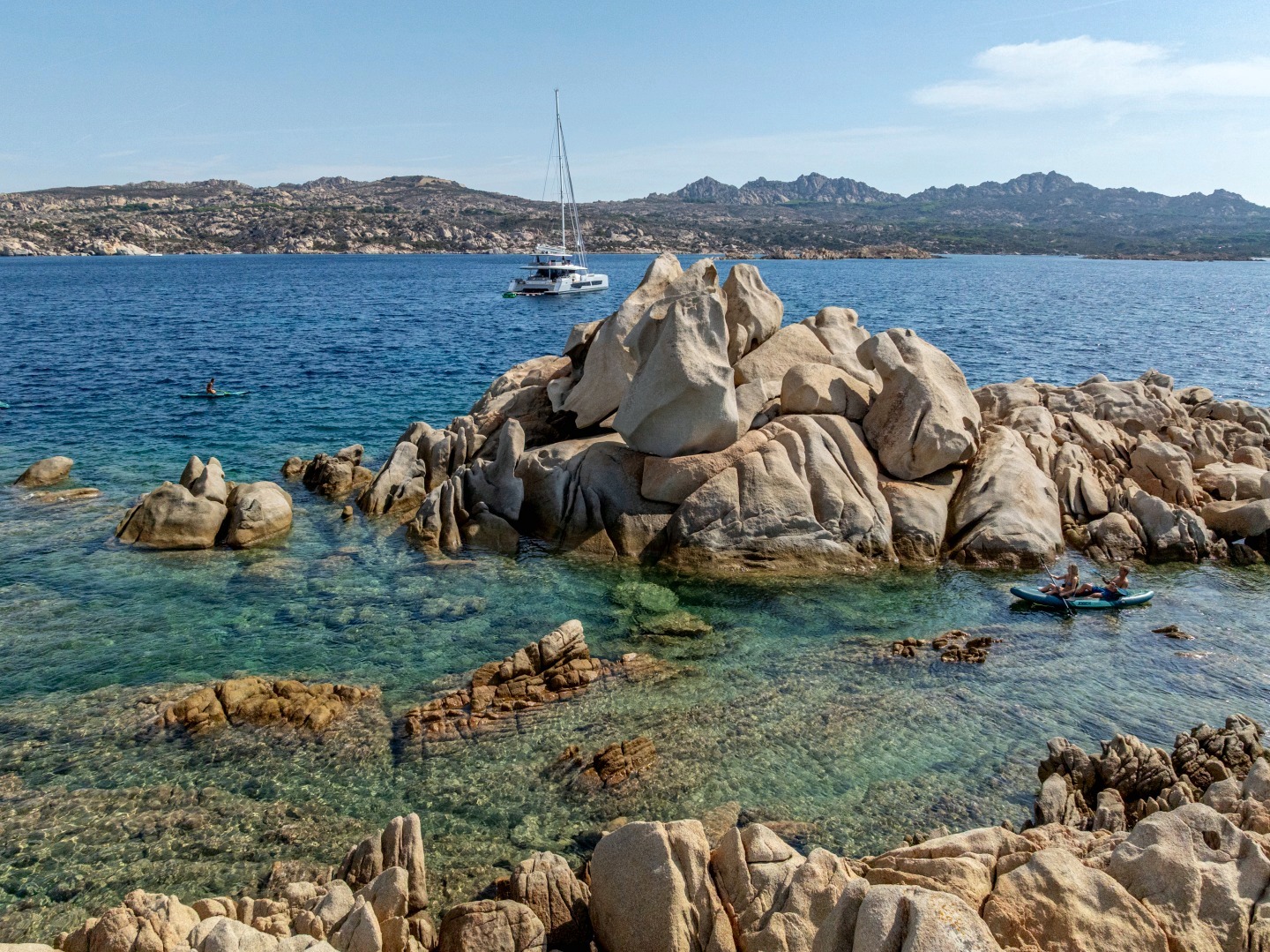 WINDKIND off the granite rocks of La Maddalena, kayak in the foreground