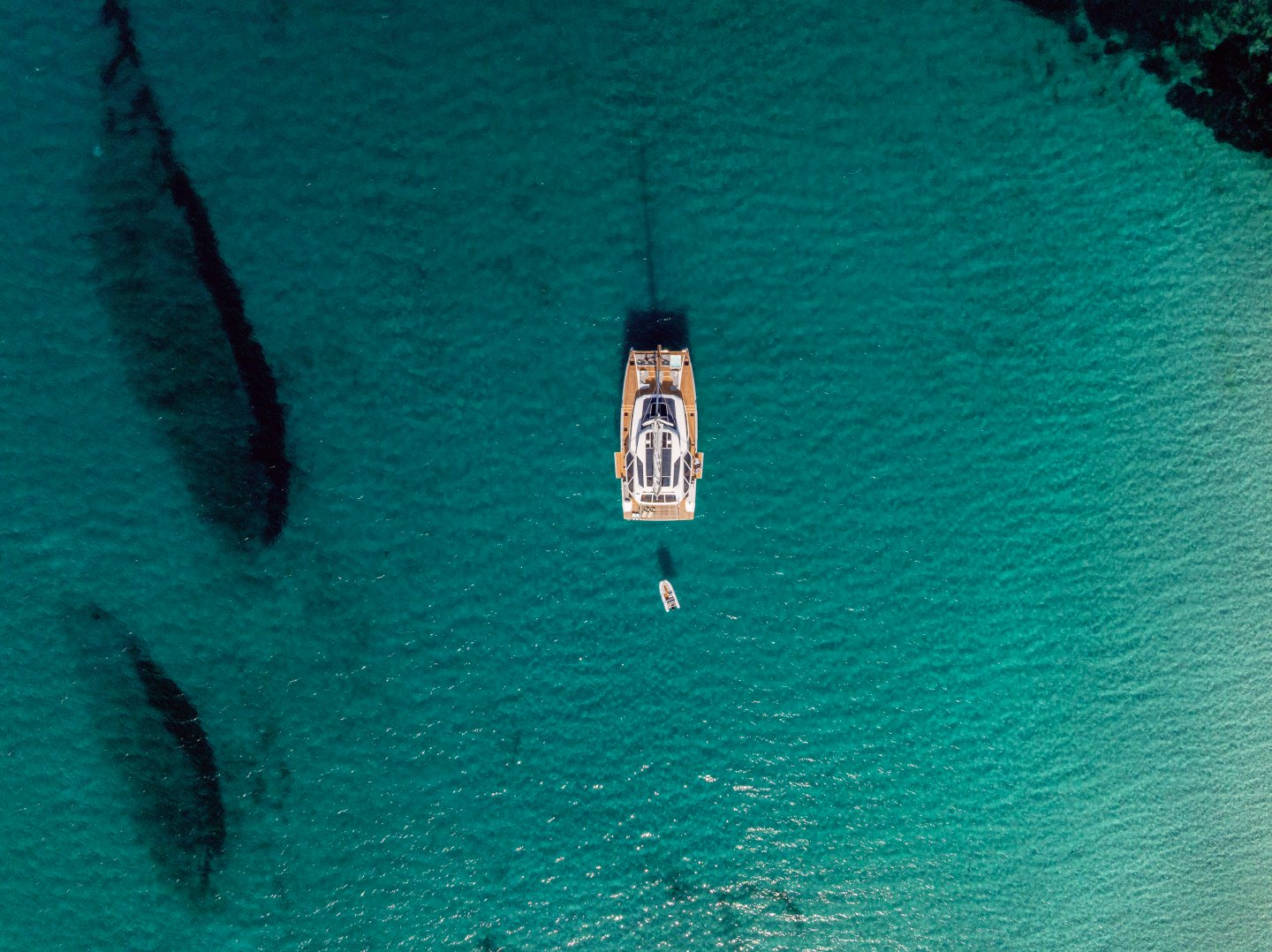 WINDKIND at anchor in turquoise water, seen from above
