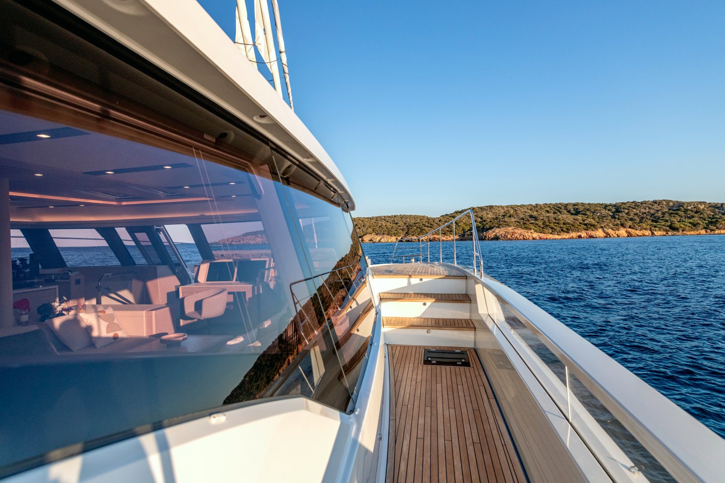 The side deck and saloon windows of WINDKIND, looking forward to a granite coast