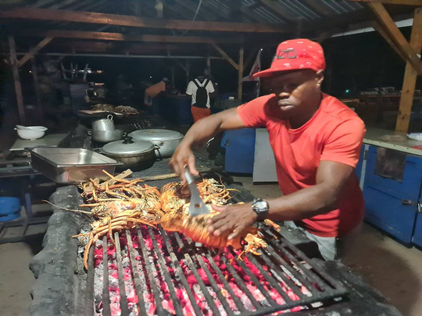 Local cook grilling lobster on the beach in the Grenadines
