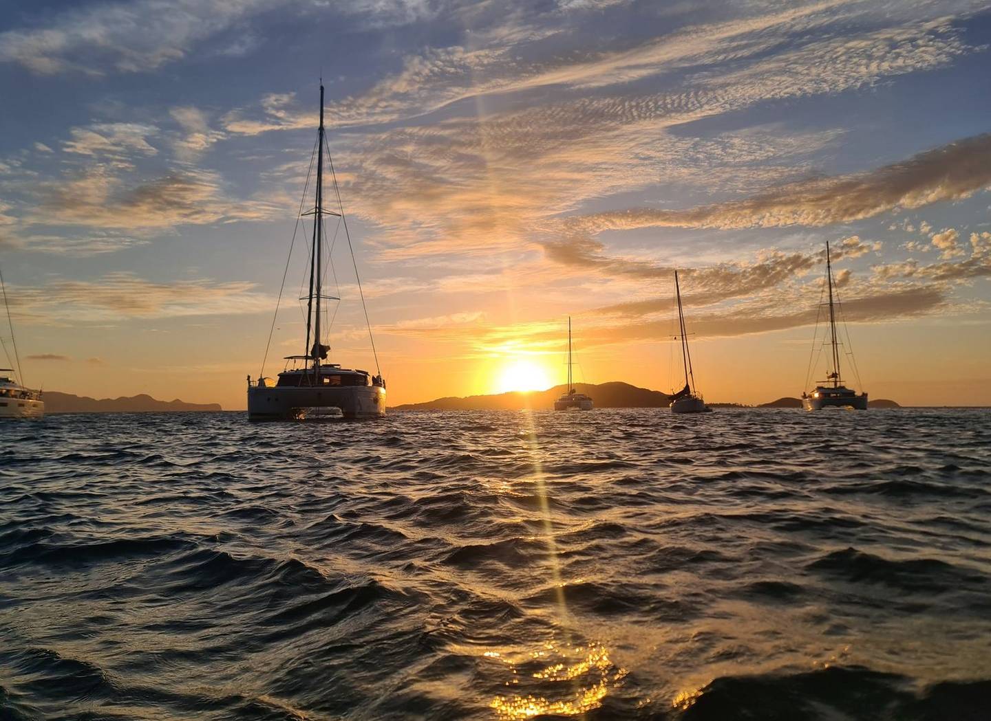 Sailing yachts at anchor at sunset in the Tobago Cays