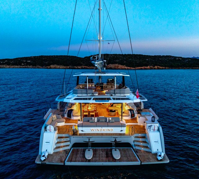 WINDKIND from astern at dusk, aft cockpit lit